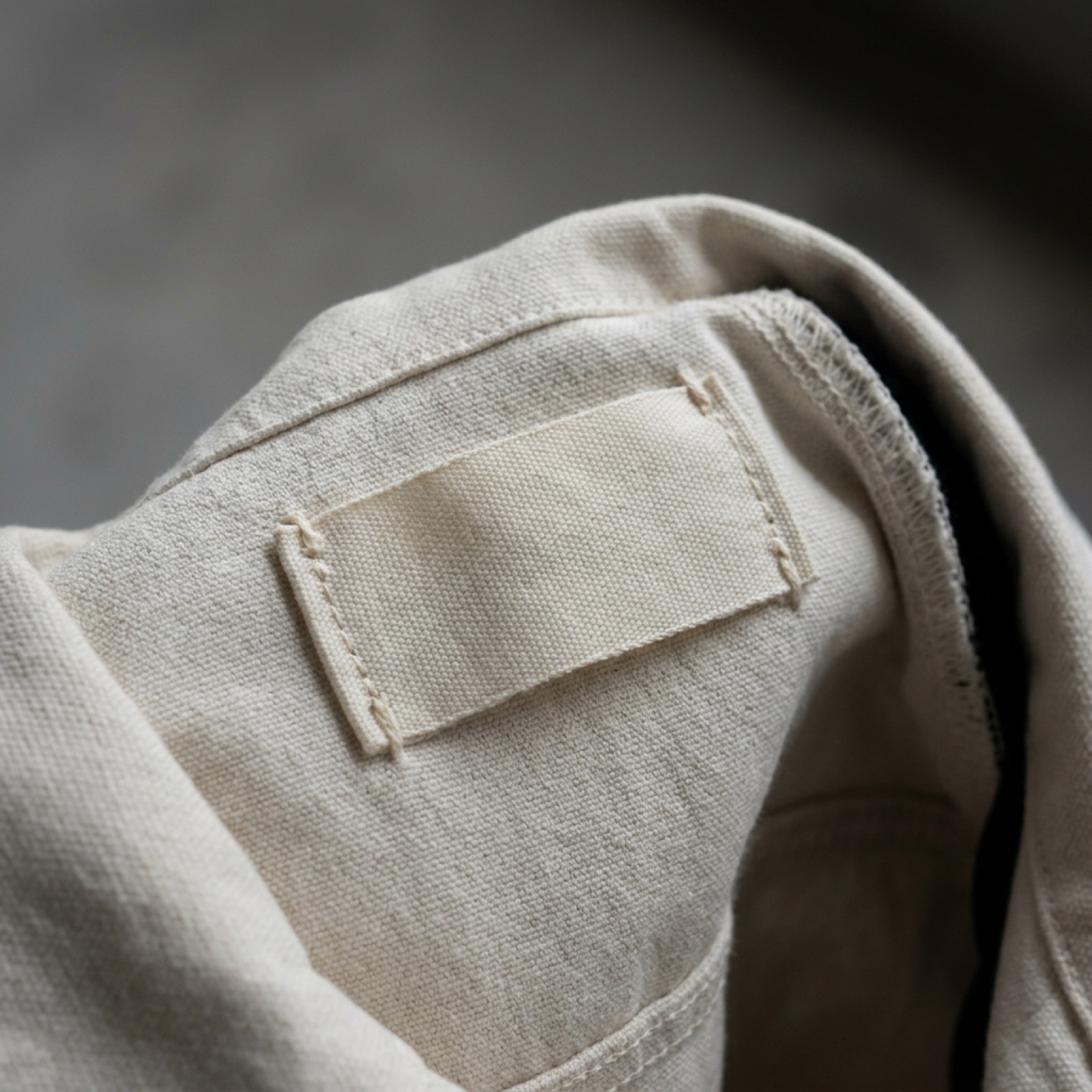 Close detail of a blank woven label stitched inside the jacket's back neck.